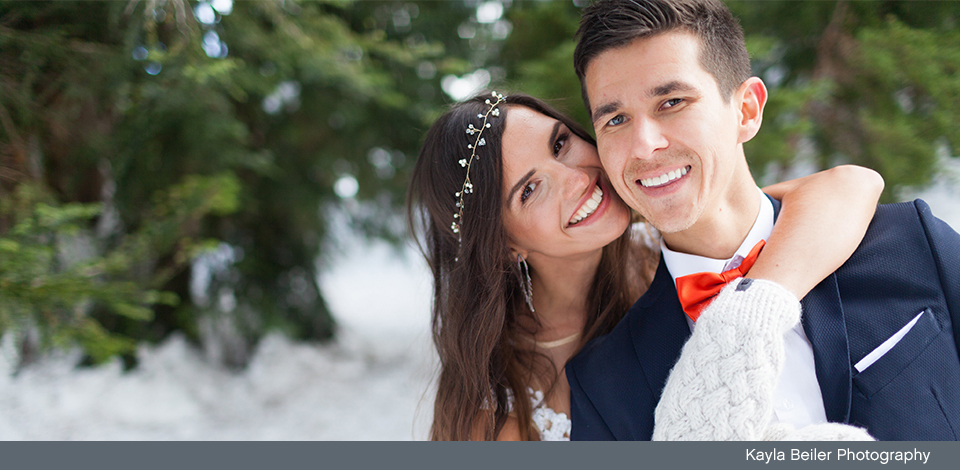 couple smiling in the snow on their wedding day