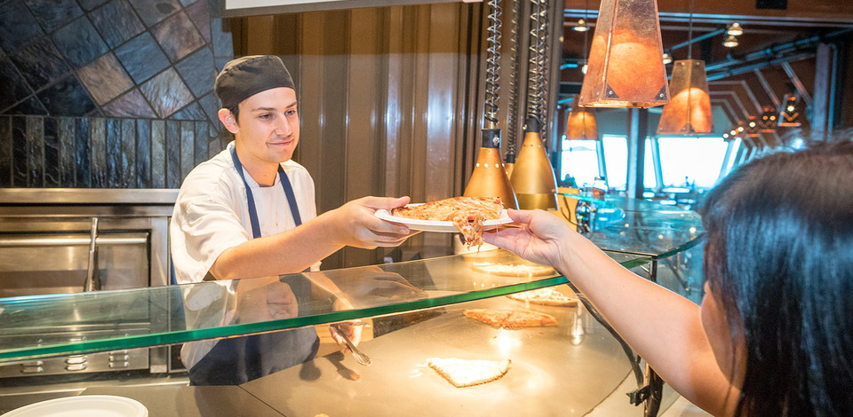 Server handing guest pizza at Lupins Cafe