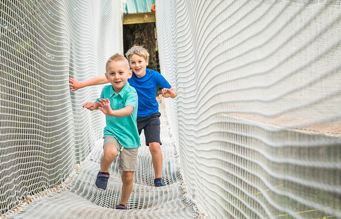 Kids running in new aerial ropes playground made for children