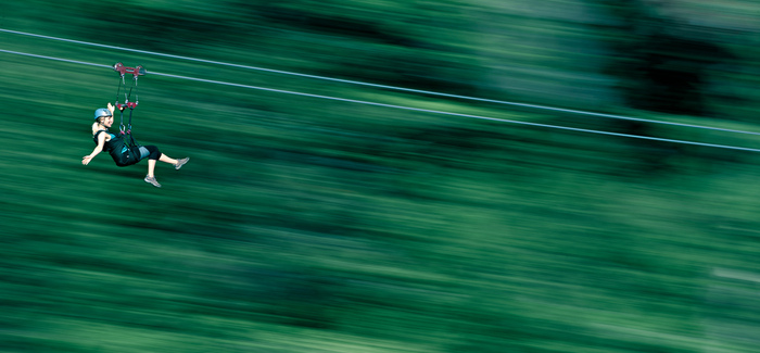 zipline going fast against a green blurred background