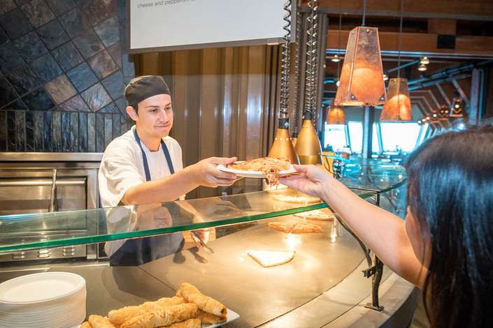 Server handing guest pizza at Lupins Cafe