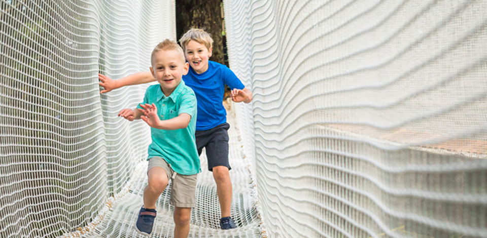 Kids running in new aerial ropes playground made for children